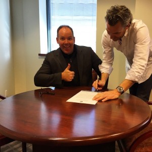 Trevor Linden signs the contract